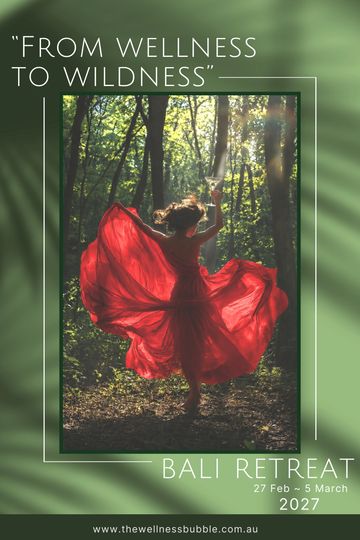 Woman in red dress dancing in forest for Bali wellness retreat.