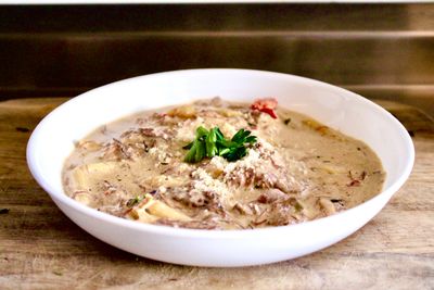Creamy mushroom soup garnished with fresh herbs in a white bowl.