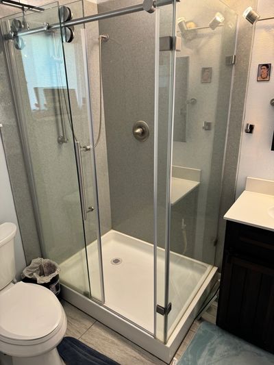 Modern glass shower enclosure in a compact bathroom.