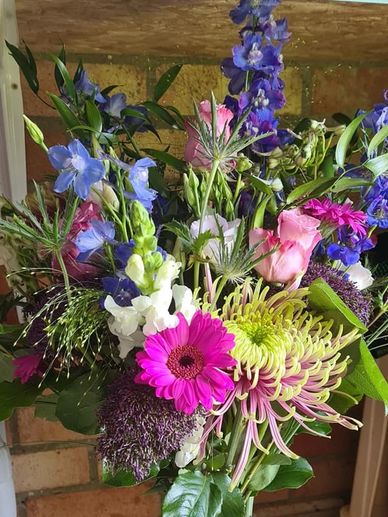 Shocking pink lime green and blue delphinium with the stunning Baltizer Chrysanthemum centre stage 
