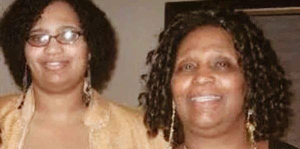 Two women smiling for the camera indoors.