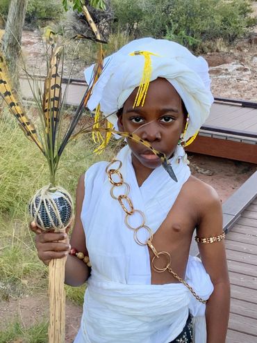 Close view of young boy,(desert Prince) holding staff with head wrap .