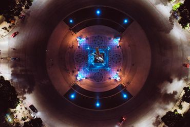 Top down view of the Angel of Independence at night with blue lights