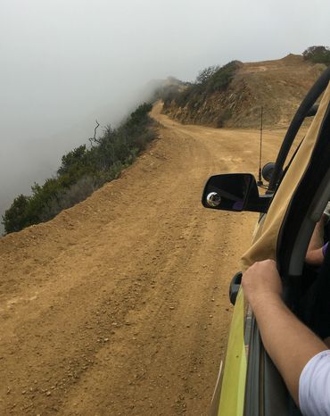 Peak out view of mountain with thick fog from Jeep.