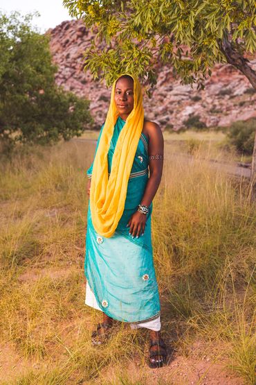 Desert woman posing with blue and gold attire.