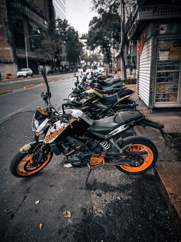 Motorcycles parked on the side of the street in Mexico City with orange highlights