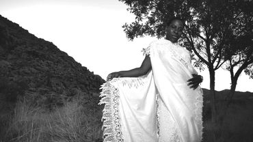 Black and white image of desert woman with white lace gown.