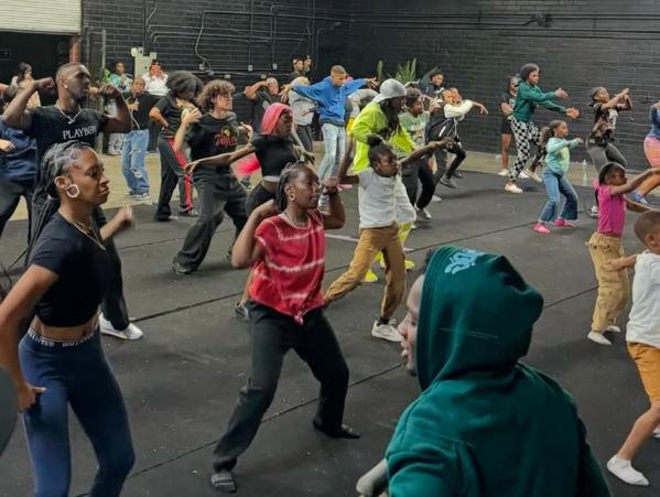 A diverse group dancing energetically in a large indoor space.