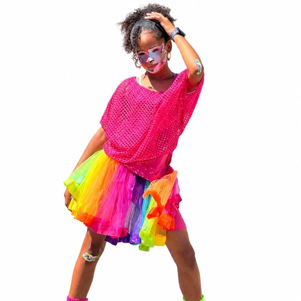 Person in colorful rainbow tutu and pink mesh top with face paint.
