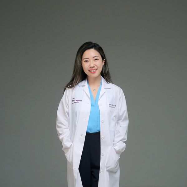 Smiling woman in a white medical coat.