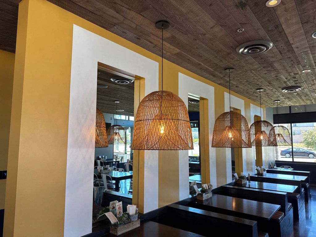 Rustic dining area with woven pendant lights and mirrored walls.
