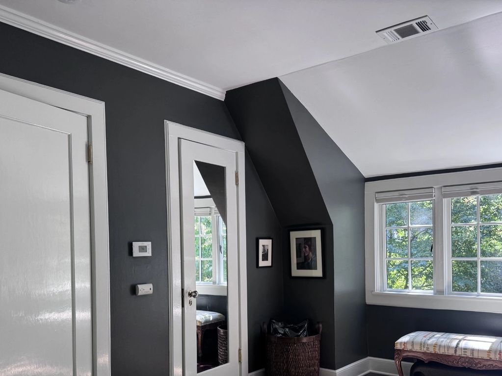 A modern room corner with dark gray walls and a large window.