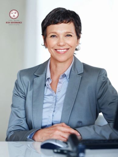 Professional woman smiling confidently in business attire at her desk.