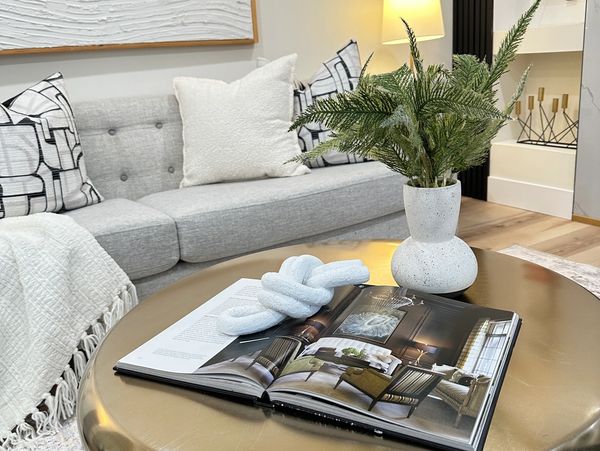 Modern living room with gray sofa, gold coffee table, and decorative accents.