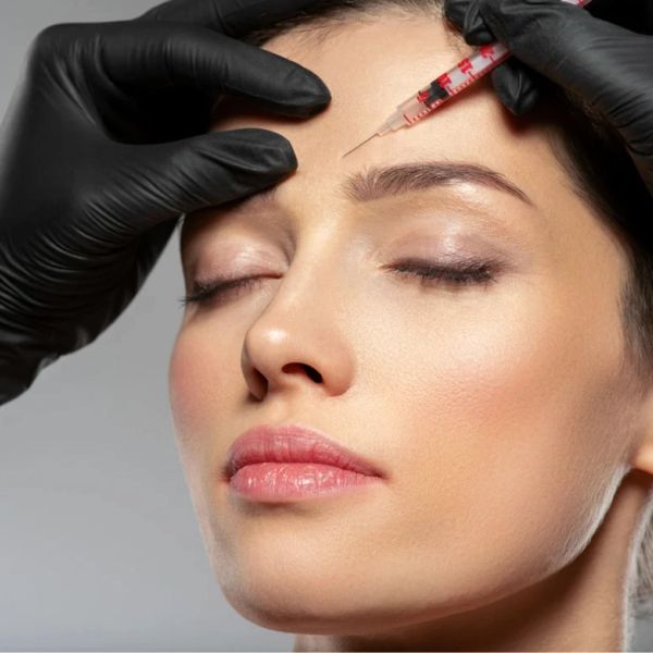 Woman receiving a Botox injection in the forehead.