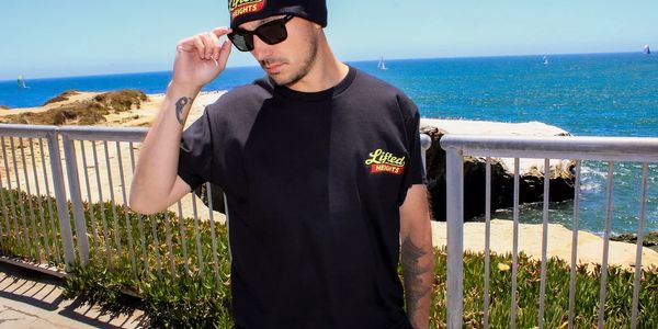 Man in black outfit with ocean background.