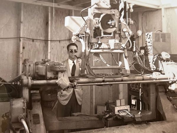 Old, black and white photo of an inventor with a satellite 
