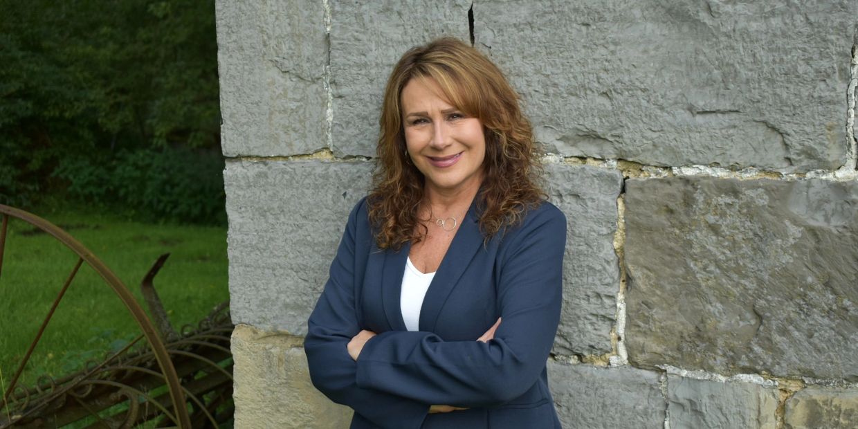 Realtor Laurie Wells posing against a wall