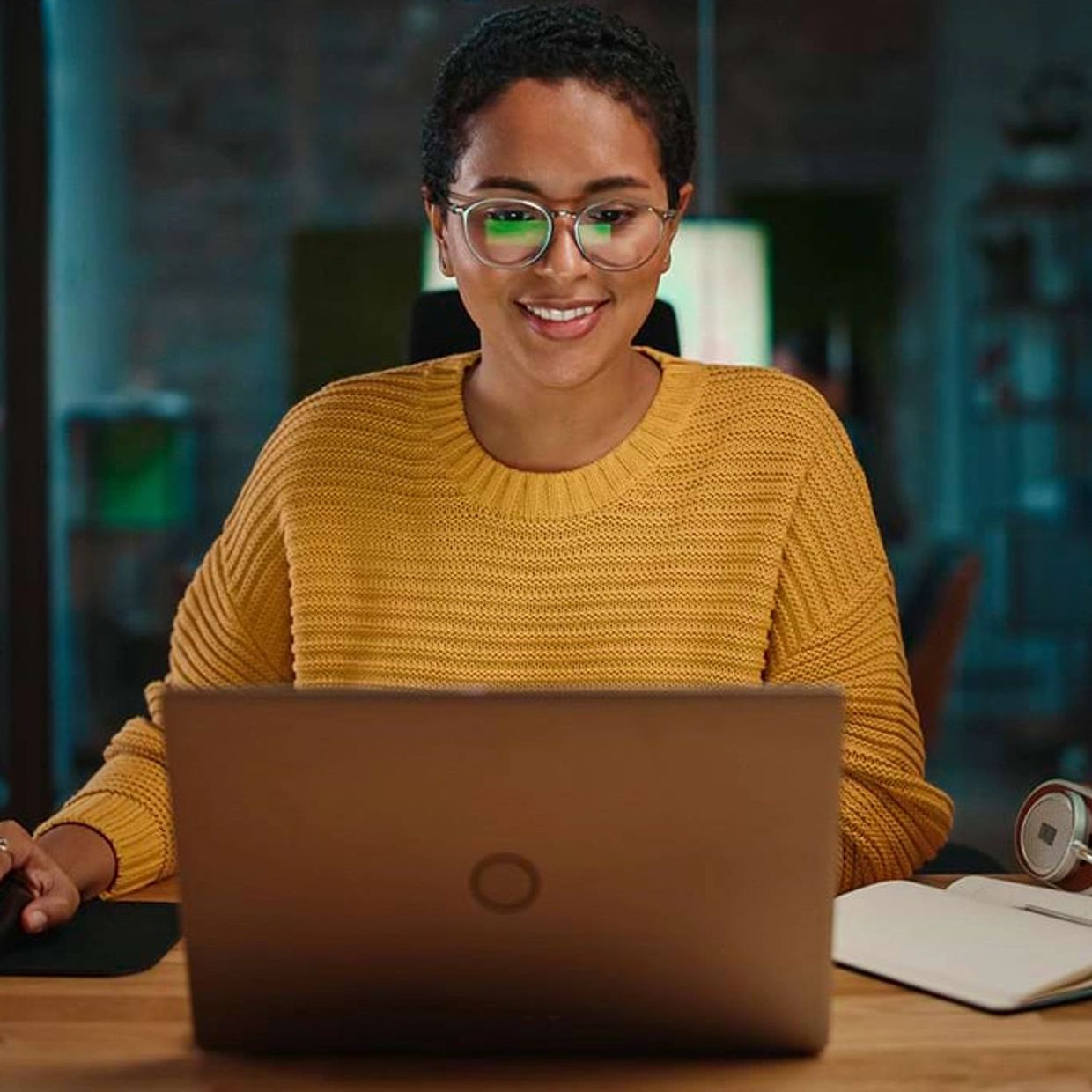 A woman looking at a laptop smiling.