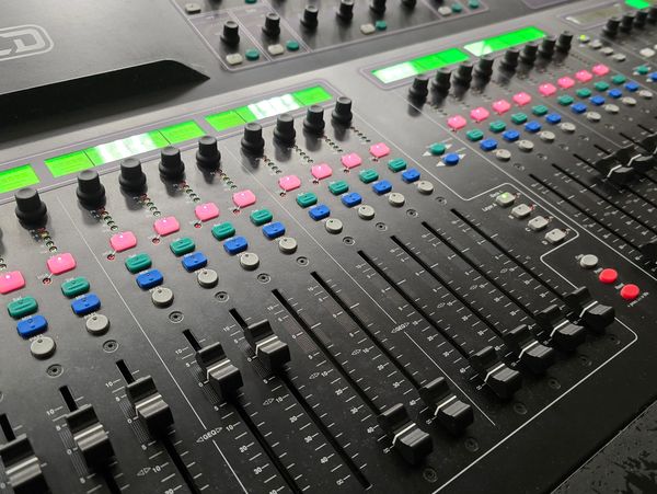 Close-up of an Allen & Heath GLD-112 audio mixing console with colorful buttons and sliders.