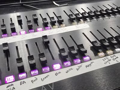 A vibrant sunset over a calm lake, with silhouettes of trees and mountains in the background.