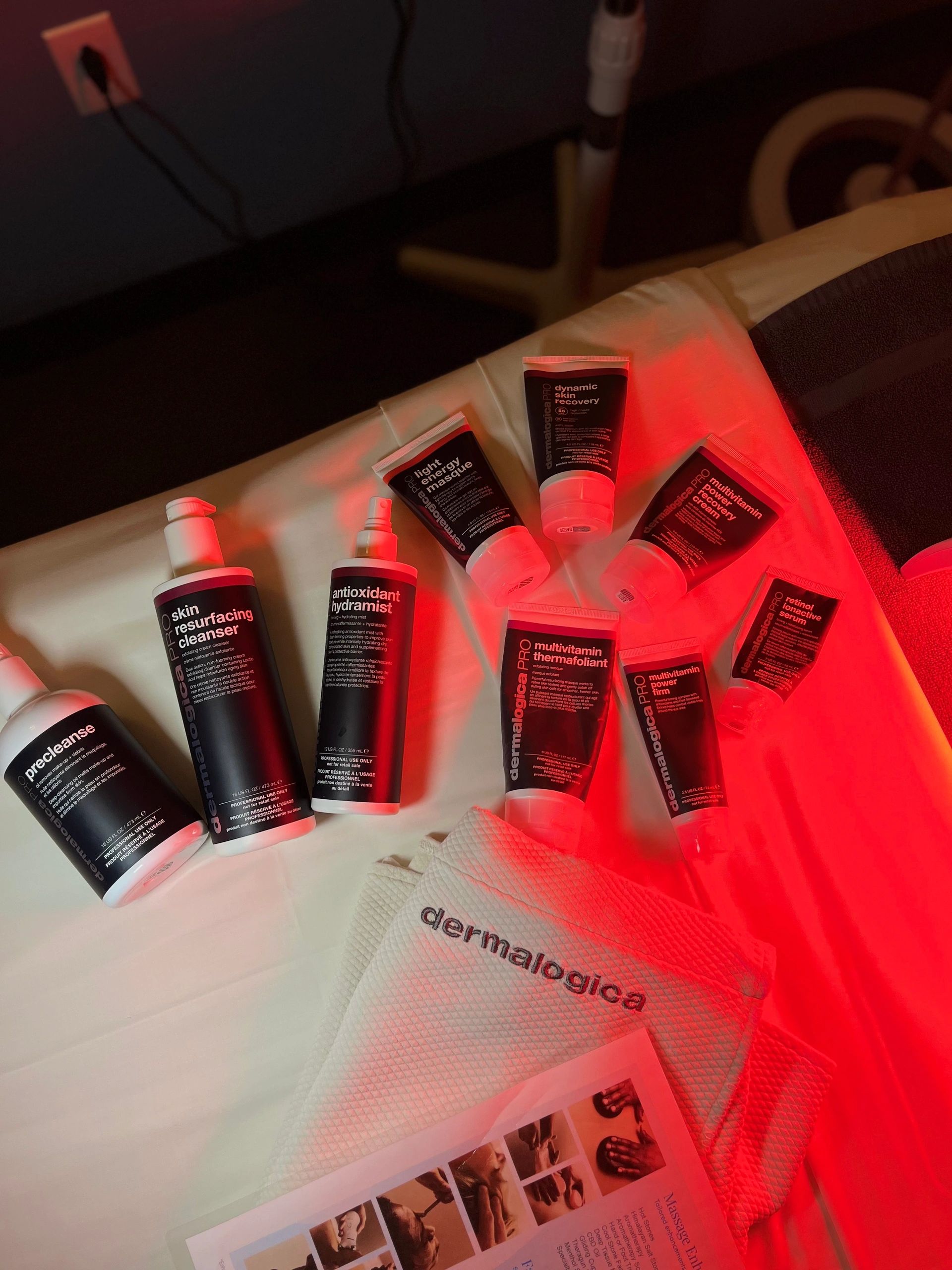 Dermalogica skincare products arranged on a surface with a warm red light.