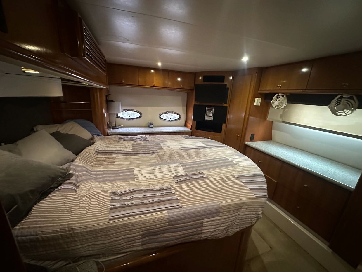 Cozy bedroom with wood-paneled walls and a bed with a striped quilt.