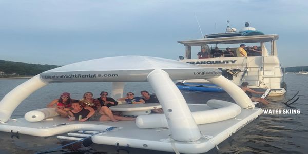 Group of people enjoying on an inflatable raft and yacht named Tranquility.