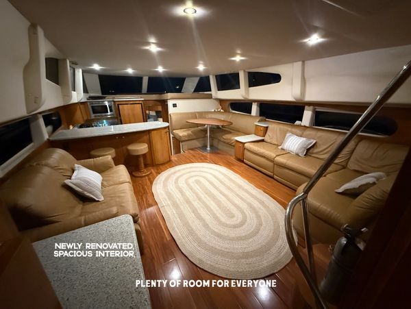 Cozy yacht interior with beige leather sofas and wooden flooring.