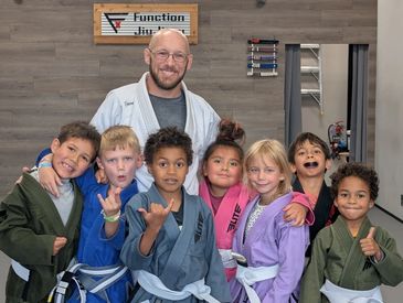 Martial arts instructor with a group of happy children in uniforms.