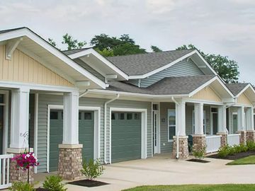 Row of modern, single-story houses with garages and porches.