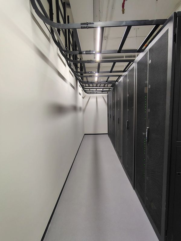 Narrow corridor with server racks on one side.