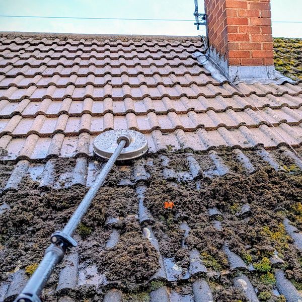 This tiled roof is in the process of getting cleaned. 