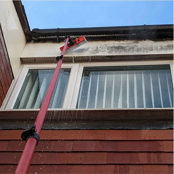 Soft washing cladding, soffits and fascias using a high reach water fed pole and brush. 