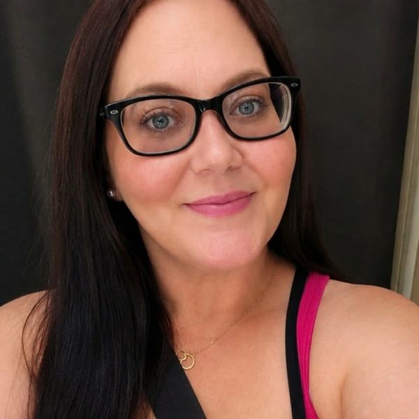 Woman with glasses smiling.
