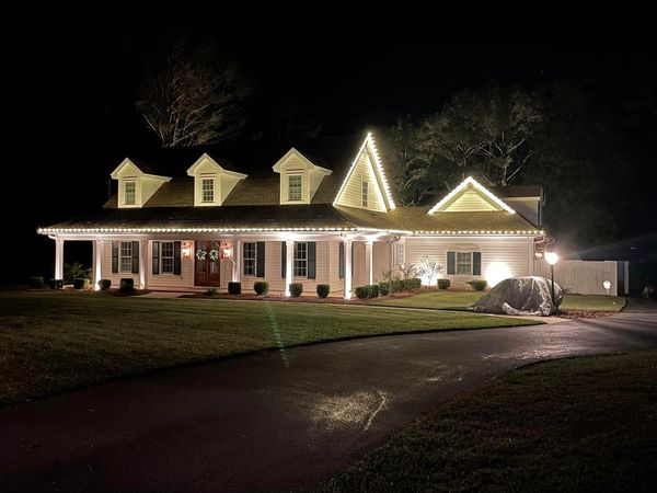 A country-style home and yard is well lit with JellyFish and landscape lighting.