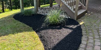 Freshly mulched garden bed with ornamental grasses.