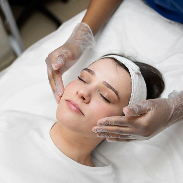 A woman receiving a gentle facial massage at a spa.