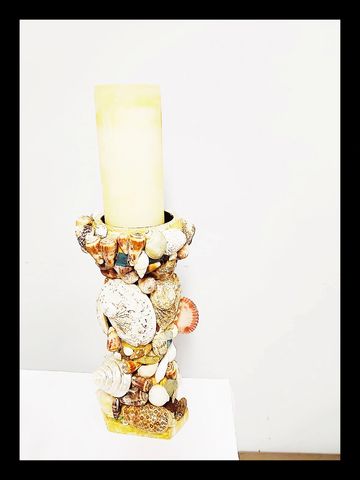 This individual seashell encrusted pillar candlestick is available to buy for $75.