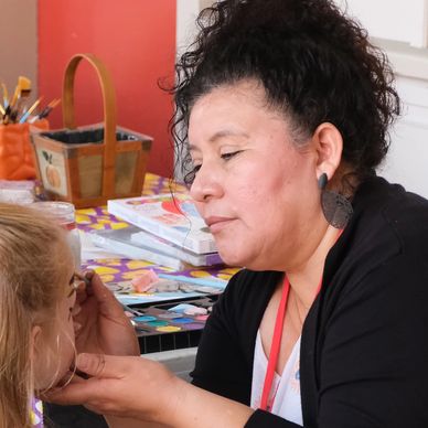 Woman painting child's face.