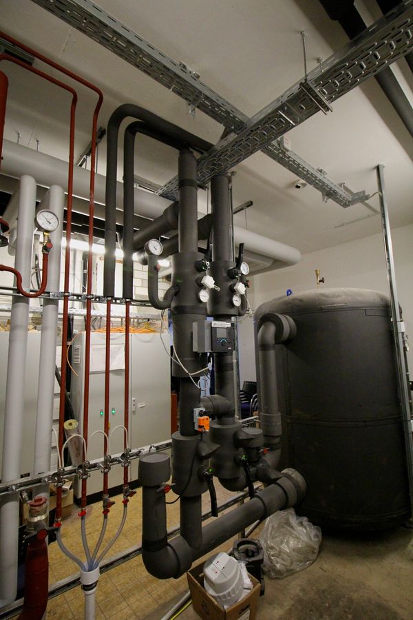 Industrial pipes and gauges in a mechanical room.