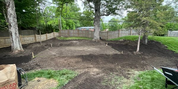 Backyard area cleared and marked for construction or gardening.