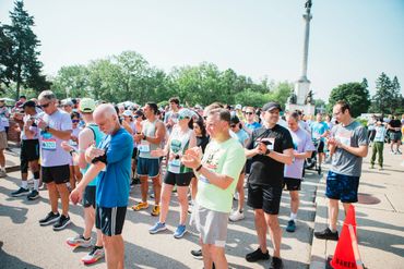 Runners checking watches before a race starts on a sunny day.