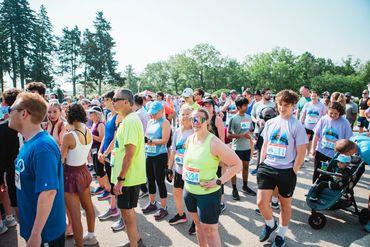 Runners gathered outdoors preparing for a race on a sunny day.