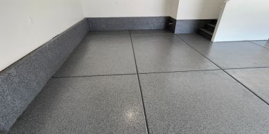 Clean, polished epoxy garage floor with gray walls.