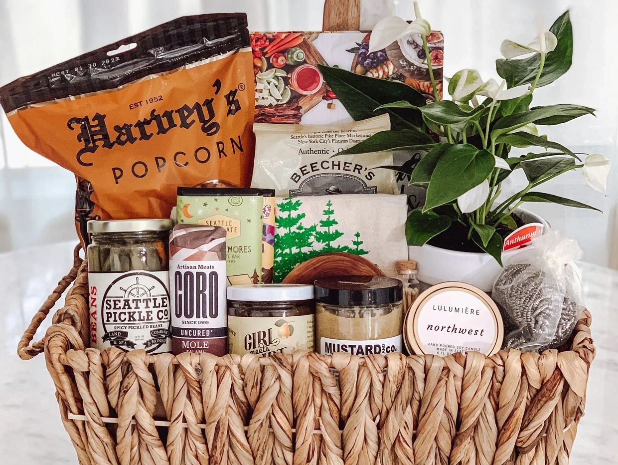 A woven gift basket filled with gourmet snacks and a potted plant.