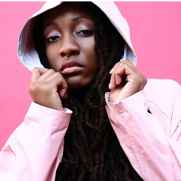 Woman in a pink hoodie against a pink background.