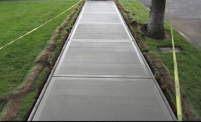 Freshly poured concrete sidewalk with grass on both sides.