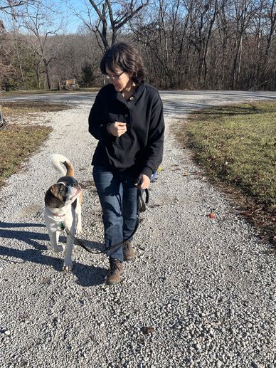 Camille walking her puppy in a heel walk with a smile in the leash, loose leash with engagement.