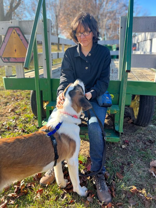 Camille sitting on a trailer with Saint Bernard sharing a special bond Divine Paws Training KC